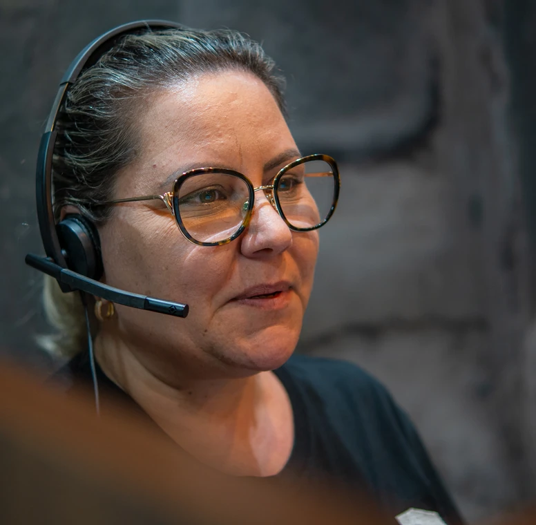 Atendente da PCE conversa com um cliente pelo headset