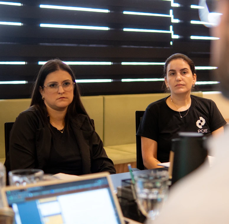 Profissionais da PCE atentas durante uma reunião