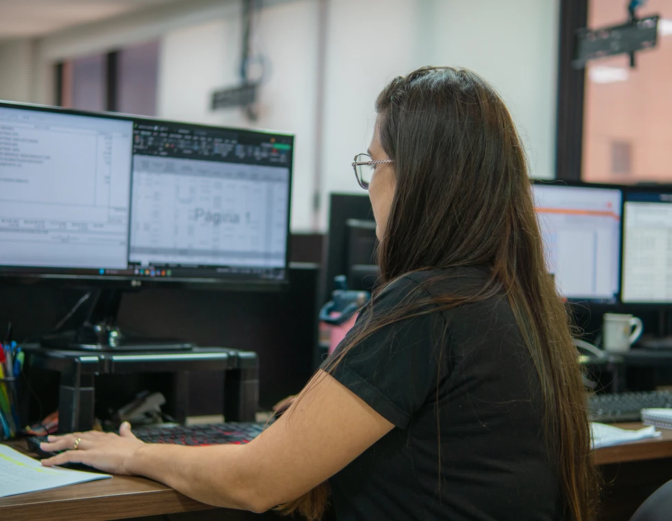 Profissional da PCE trabalha em dois monitores