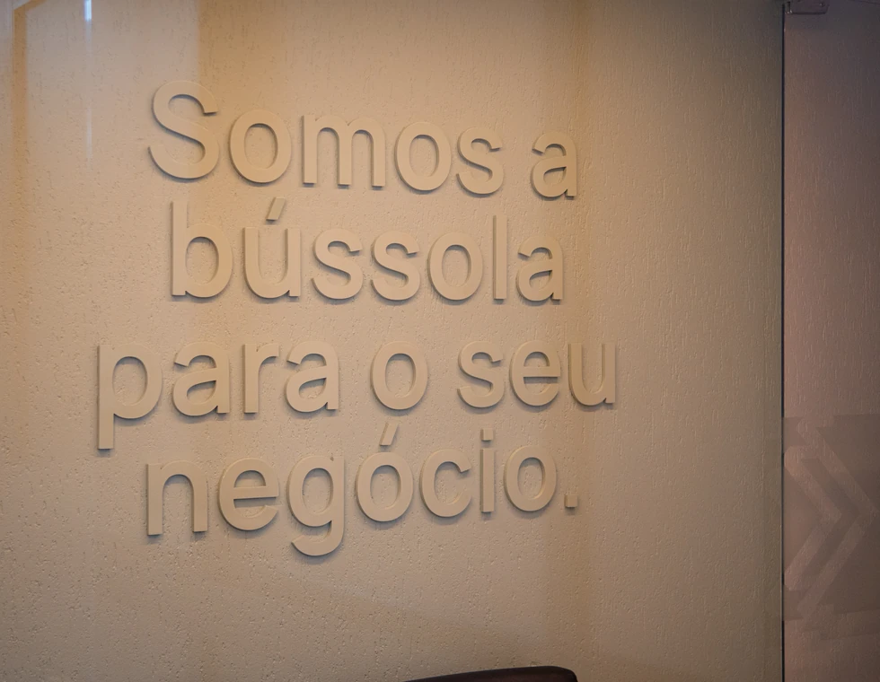 Parede da PCE com a frase Somos a bússola para o seu negócio