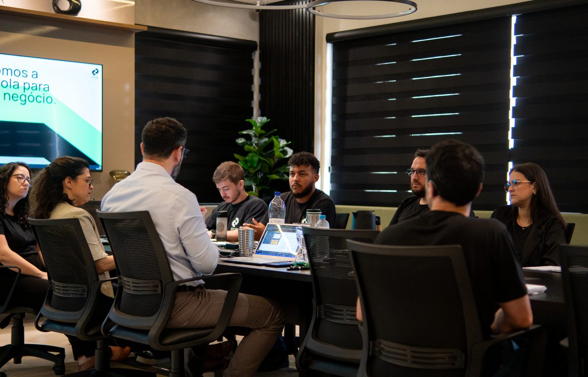 Reunião da equipe da PCE com clientes em sala de reunião