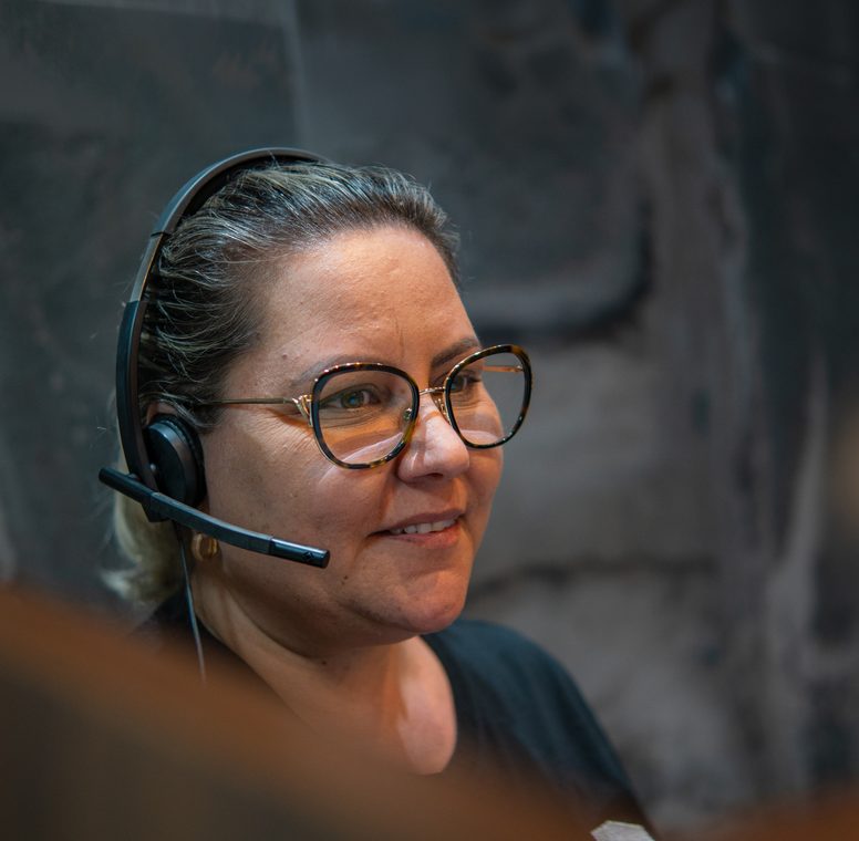 Profissional da PCE em atendimento com headset